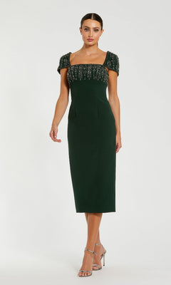 Woman wearing a green dress with beaded top on a white background