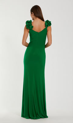 A woman stands with her back to the camera against a plain background, showcasing the Long Formal Dress: Mac Duggal 44094. This elegant green gown features 3D shoulder straps and ruffled details for a strikingly sophisticated look.
