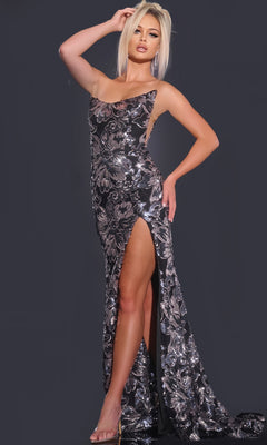 A woman poses against a dark background in the Jovani 44116 Strapless Floral-Sequin Prom Gown—a floor-length silver gown with shimmering floral sequins and a high leg slit.