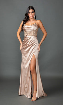 A woman models the Sheer-Waist Long Prom Dress: Dancing Queen 4416 in champagne, featuring a thigh-high slit, lace bodice, and spaghetti straps against a plain gray background, highlighting this gown’s elegant formal style.