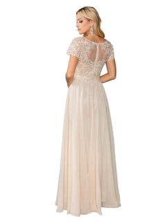 A woman stands looking over her shoulder in the Dancing Queen 4433 Short Sleeve Long Prom Dress, featuring a floor-length light beige design with lace bodice detailing and a sheer back.