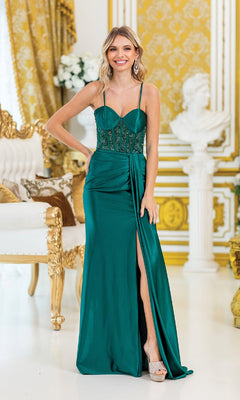 Wearing the Drape-Front Long Prom Dress: Dancing Queen 4439, a woman smiles at the camera in an ornate gold and white room, showcasing the green gown's lace-up back and thigh-high slit.