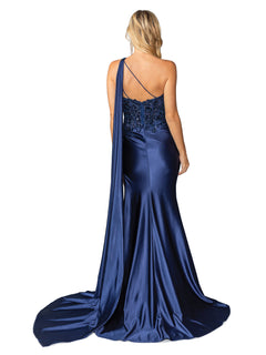 A woman faces away from the camera in the One-Shoulder Long Prom Dress: Dancing Queen 4441, a dark blue satin gown with a floor-length train, beaded-lace bodice detail, and single back strap.