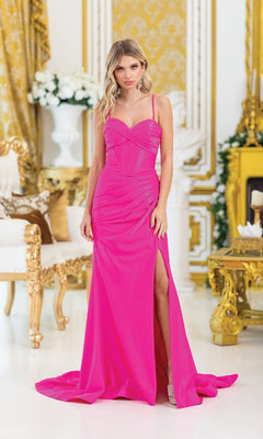 A woman in the Lace-Up Long Corset Prom Dress: Dancing Queen 4456, a bright pink gown with a thigh-high slit, stands in an opulent gold and white room featuring ornate furniture and elegant floral arrangements.