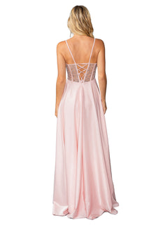 A woman faces away in the Dancing Queen 4463, a long blush pink prom dress featuring thin straps, a lace-up semi-sheer back, and an elegant A-line silhouette.
