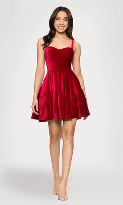 A woman in the Sapphire Blue Short Velvet Hoco Dress 4469BN with a sweetheart neckline and silver high-heeled sandals stands against a plain light background.