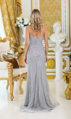 A woman with wavy blonde hair stands with her back to the camera in an opulent gold and white room, wearing the Long Beaded Silver Prom Dress: Dancing Queen 4487.