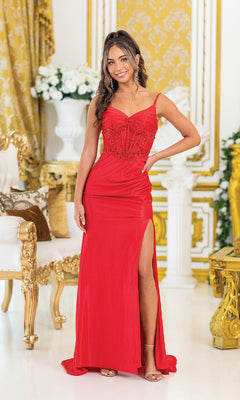 Wearing the Lace-Up Long Jersey Prom Dress: Dancing Queen 4492, a woman stands indoors near ornate gold and white furniture and floral arrangements, smiling at the camera.