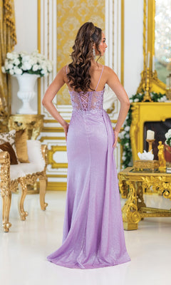 A woman wears the Embellished-Bodice Prom Gown: Dancing Queen 4495, a shimmery lavender formal dress with a detailed bodice, standing with her back to the camera in a gold-accented room adorned with white floral arrangements.