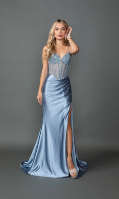 A woman in the Sheer-Corset Long Prom Dress: Dancing Queen 4507 in dusty blue, featuring a beaded sheer bodice and high slit, stands before a plain gray background.