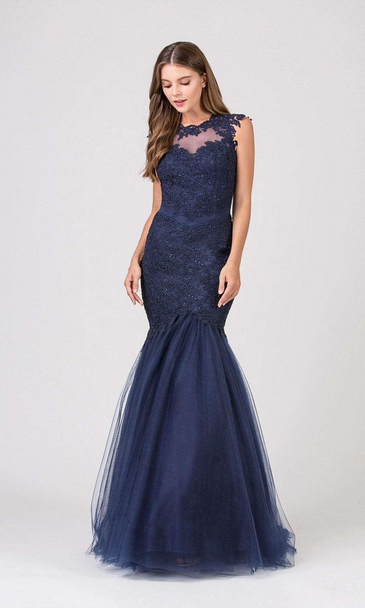 A woman poses against a plain light background in the Eureka 4510 long prom dress, featuring a navy blue mermaid tulle silhouette and a lace illusion neckline.