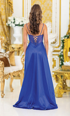 A woman wearing the Overskirt Long Prom Dress: Dancing Queen 4519 stands with her back to the camera in an ornate gold and white room decorated with flowers.