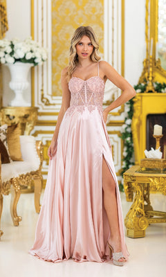 A woman wearing the Sheer-Waist Long Prom Dress: Dancing Queen 4520—a light pink sweetheart gown with beaded embroidery and a thigh-high slit—stands in an ornate gold and white room.