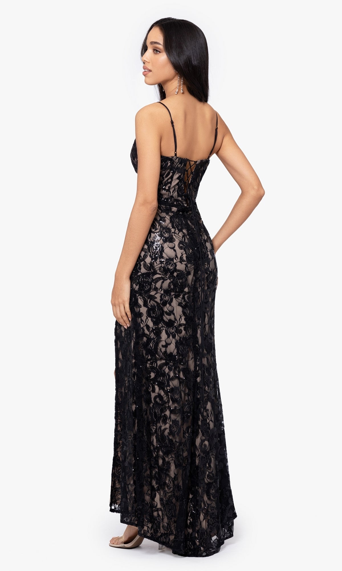 Woman wearing the Sequin-Lace Long Lace-Up Prom Dress 4521BN, a black junior evening gown with sequins and spaghetti straps, shown from the back against a plain white background.