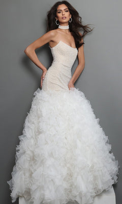 A woman wearing the Jovani 45339 long formal dress in off-white/nude, featuring a strapless fitted beaded bodice and a voluminous ruffled skirt, poses against a plain gray background.