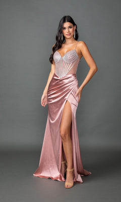 A woman in the Dancing Queen 4538 long prom dress—sleeveless, light pink, beaded bodice with a satin skirt and high slit—stands against a plain gray background.