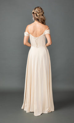A woman faces away, wearing the Dancing Queen 4539 long prom dress—a cream, off-shoulder A-line gown with a corset bodice and lace-up back. Her hair is styled in loose waves and braids.