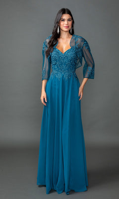A woman models the Dancing Queen 4542 long prom dress in teal, featuring lace embroidery and a sheer matching shawl, against a plain gray backdrop.