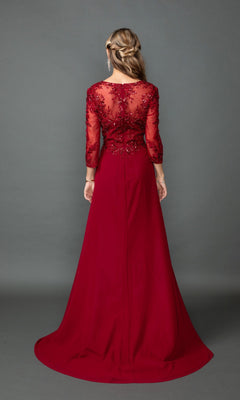 A woman stands with her back to the camera in a floor-length Dancing Queen 4543 gown featuring a sequin lace bodice and sheer embroidered long sleeves, set against a plain gray background.