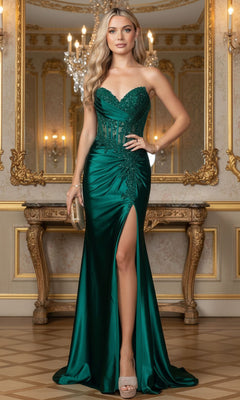 Woman wearing the Dancing Queen 4560 long prom dress, featuring a strapless dark green design with a beaded lace corset and thigh-high slit, stands in an ornate room with gold accents and sparkling chandeliers.