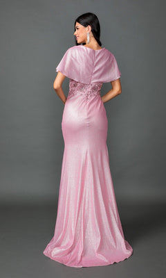 A woman stands facing away against a plain gray background, wearing the Dancing Queen 4568 long prom dress featuring shimmering pink fabric with cape sleeves and lace detailing.