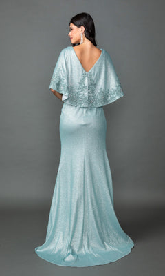 A woman is seen from behind, standing against a gray backdrop and wearing the Dancing Queen 4569 long formal dress—a shimmering light blue gown featuring a ruched fitted bodice and elegant capelet detail.