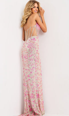 A woman wearing the Jovani 45774 long prom dress with pink and silver beaded embellishments stands facing a white wall, looking over her shoulder and smiling.