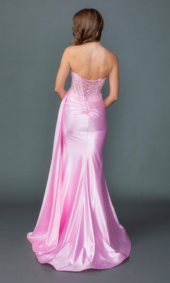 A person is seen from behind, standing against a plain gray background and modeling the Long Prom Dress: Dancing Queen 4603. The gown features a pink strapless design with a floor-length satin skirt, lace-up back, and delicate floral lace appliqué, creating an elegant sheath silhouette for a timeless look.
