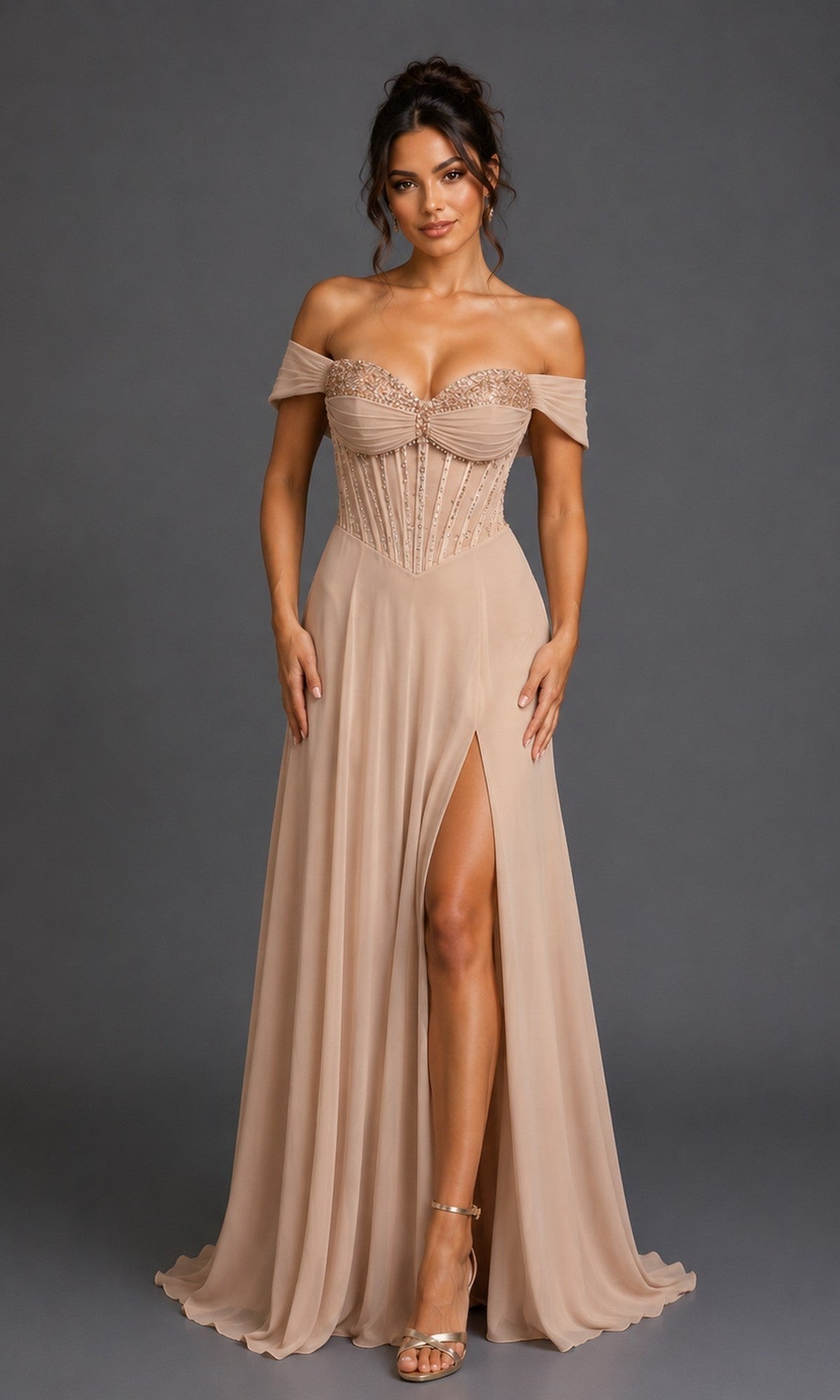 A woman wearing the Dancing Queen 4615 long prom dress in champagne, featuring an off-the-shoulder design with an embellished corset bodice and a nude-colored, beaded A-line skirt with a thigh-high slit, stands against a plain gray background.