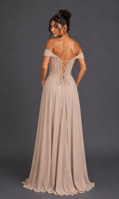 A woman wearing the Dancing Queen 4615 long prom dress, featuring an off-shoulder, light beige floor-length gown with an embellished corset bodice and lace-up back, stands against a dark background.