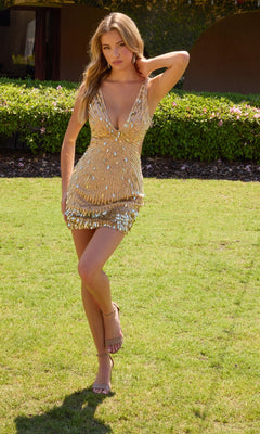 A woman in the Primavera 4617 short homecoming dress, featuring sleeveless gold sequins and iridescent teardrop accents, stands on grass with one arm raised, shimmering against a lush green backdrop.