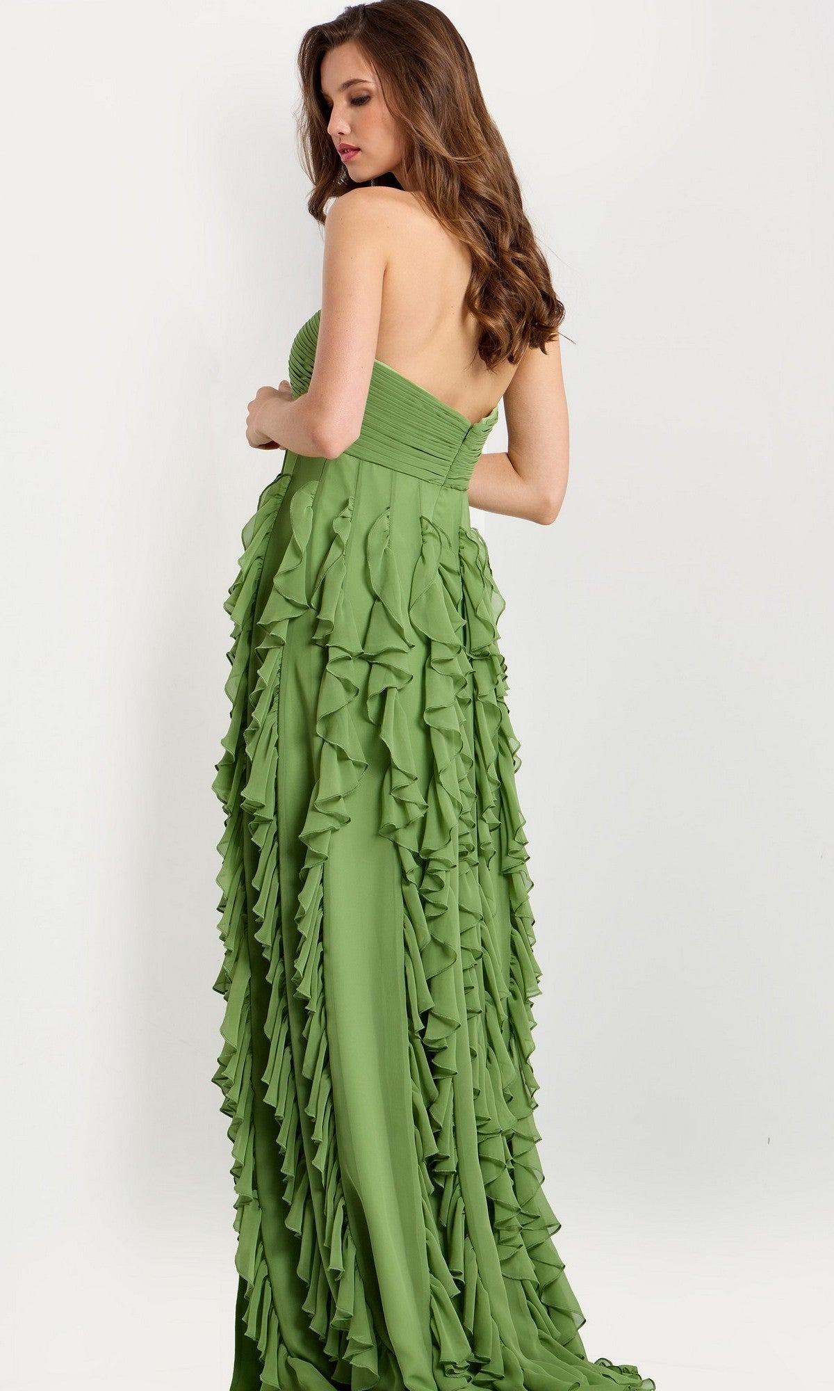 A woman with long brown hair models the Jovani 46379 long strapless prom dress, which features a ruched bodice and layered ruffle details, standing against a plain light background.