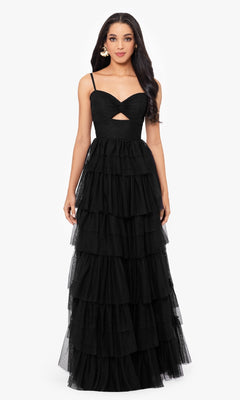 A woman poses against a plain white background wearing the Blondie Nites 4637BN, a long ruffled A-line prom dress with spaghetti straps and a small chest cutout.