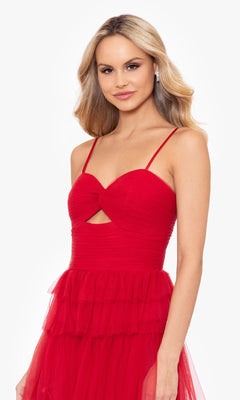 A woman wears the Long Ruffled Prom Dress: Blondie Nites 4637BN, a sleeveless red A-line gown with spaghetti straps, sweetheart cutout bodice, and tiered tulle skirt, standing against a plain white background.