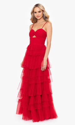 A woman models the Blondie Nites 4637BN Long Ruffled Prom Dress—sleeveless, red, with a sweetheart bodice, tiered tulle layers, thin straps, and a lace-up back—against a plain white background.