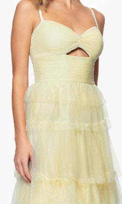 A woman wears the Blondie Nites 4637BN long ruffled prom dress, featuring light yellow tiered tulle, a sleeveless sweetheart bodice with a front cutout, and an A-line silhouette.