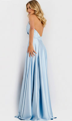 A woman stands facing away, looking over her shoulder in the Jovani 46483 long prom dress—light blue, backless, with delicate beaded trim—against a plain white background.