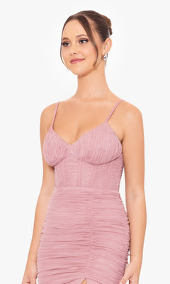 Woman wearing the Corset-Bodice Long Mermaid Prom Dress 4682BN, featuring a mauve ruched spaghetti strap design, with her hair in an updo, standing against a plain white background.