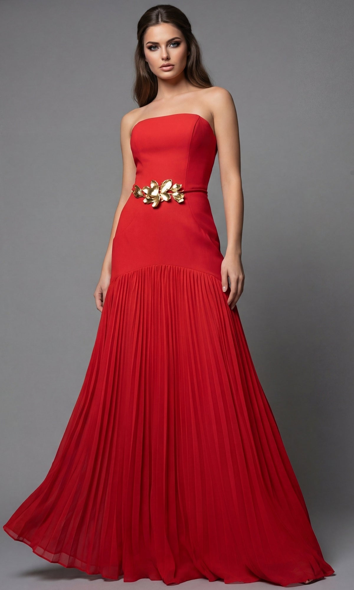 A strapless red Jovani 47000 floor-length gown with a pleated skirt and a gold floral belt.