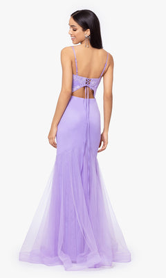 A woman smiles while facing away in the Blondie Nites Lilac Purple Long Prom Dress 4706BN, featuring a sleeveless, backless design with lace-up detailing and a tulle mermaid skirt.