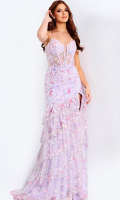 A woman stands against a plain white background wearing the Jovani 47101, a long light purple prom dress featuring embellished tulle, floral patterns, spaghetti straps, a deep neckline, and a high slit.