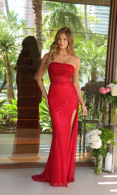 Indoors, a woman wears the Ava Presley 47114 long prom dress—strapless, glittery, with a thigh-high slit—against a backdrop of tropical plants and flowers.