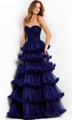 A woman poses against a white background in the elegant Long Prom Dress: Jovani 47139, featuring strapless styling and ruffled tiers with navy blue layers flowing gracefully.