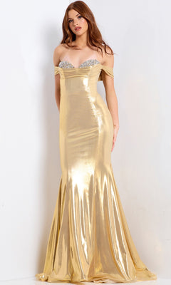 A woman stands against a plain white background wearing the Jovani 47153 long prom dress, featuring shiny gold metallic fabric, a fitted bodice, an embellished sweetheart neckline, and a floor-length skirt.