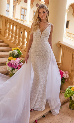 A woman wearing the Ava Presley 47224 long formal dress in ivory, featuring a fitted sleeveless design, open back, beaded details, and long sheer train, stands on a flower-adorned staircase.
