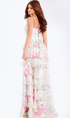 Woman models the Jovani 47282 long prom dress—a tiered, floral pastel maxi with thin straps, corset bodice, and lace-up back—while standing against a plain background.