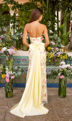 Back view of the Long Prom Dress: Ava Presley 47396, a strapless floral gown featuring a large yellow bow at the lower back and a long, flowing train.