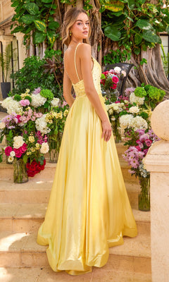 A person stands on stone steps surrounded by vases of flowers wearing a sparkly, floor-length yellow Long Prom Dress: Ava Presley 47403 with beaded straps.