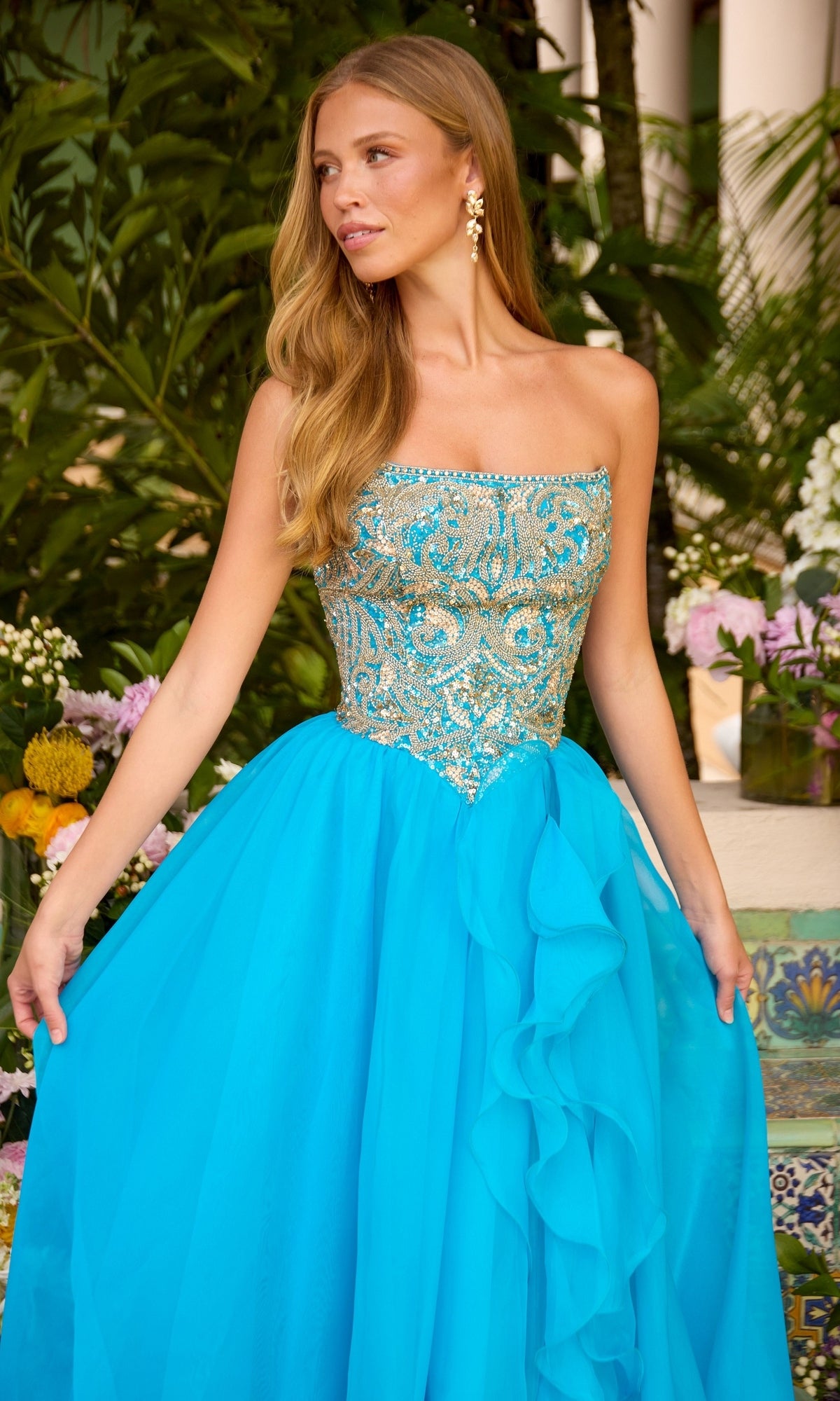 The strapless Long Prom Dress: Ava Presley 47420 features a bodice with intricate gold embroidery and a voluminous bright blue tulle skirt.