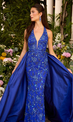 A woman wears a royal blue, floor-length Long Prom Dress: Ava Presley 47421 featuring an embellished floral bodice and a detachable overskirt.
